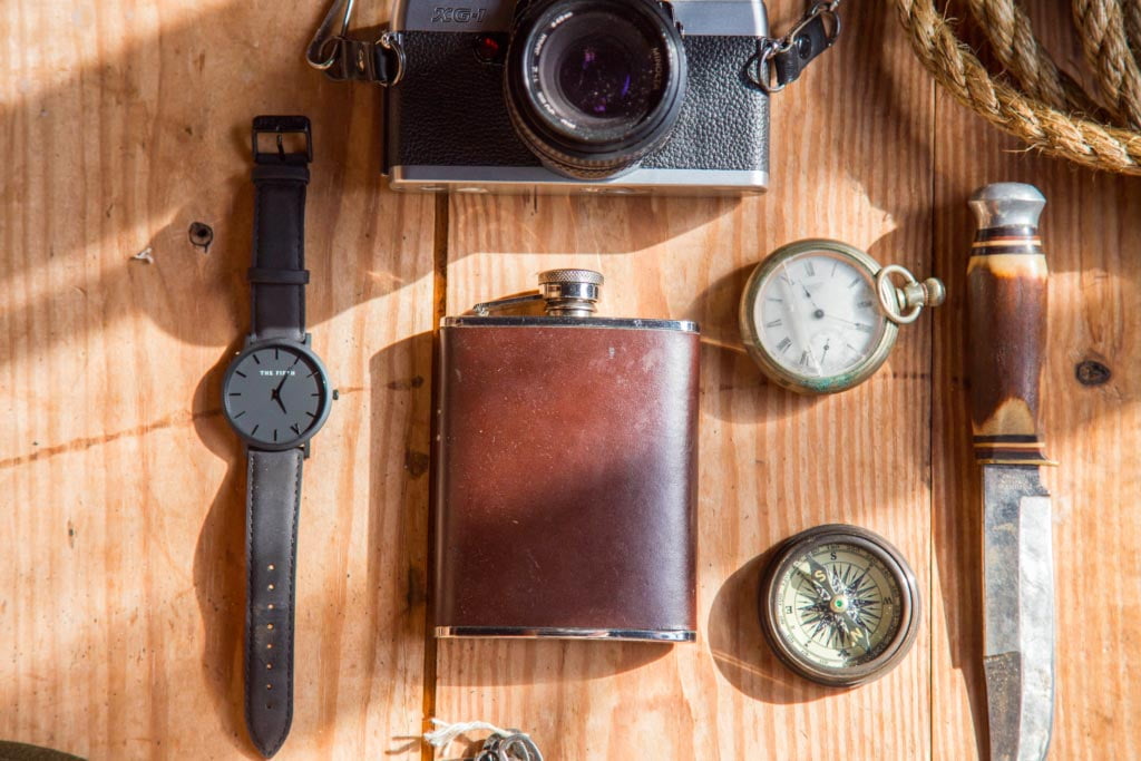 A watch with an old camera and hip flask